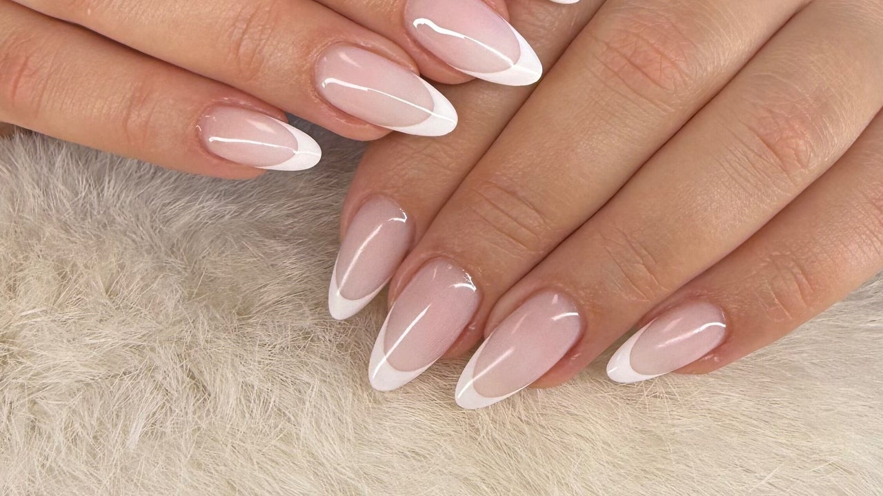 Lange amandelvormige nagels met een witte French op een crèmekleurige vacht
