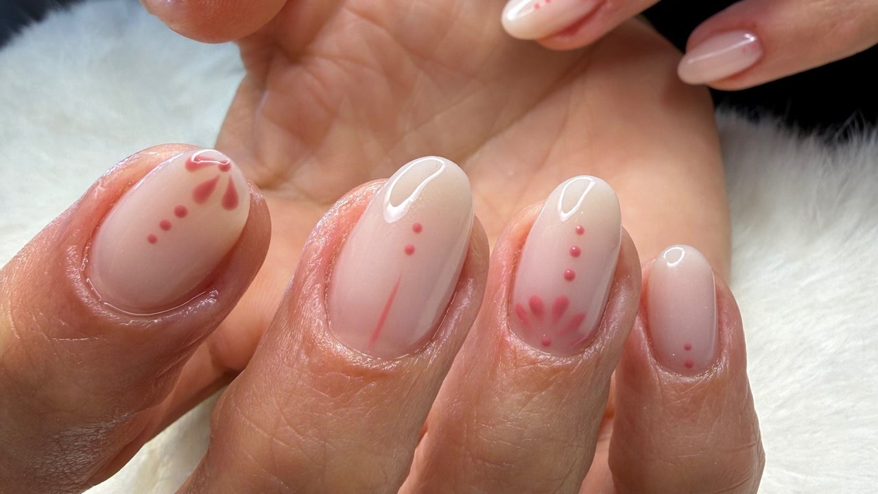 Zachte nude nagels met kleine rode stipjes als nail art